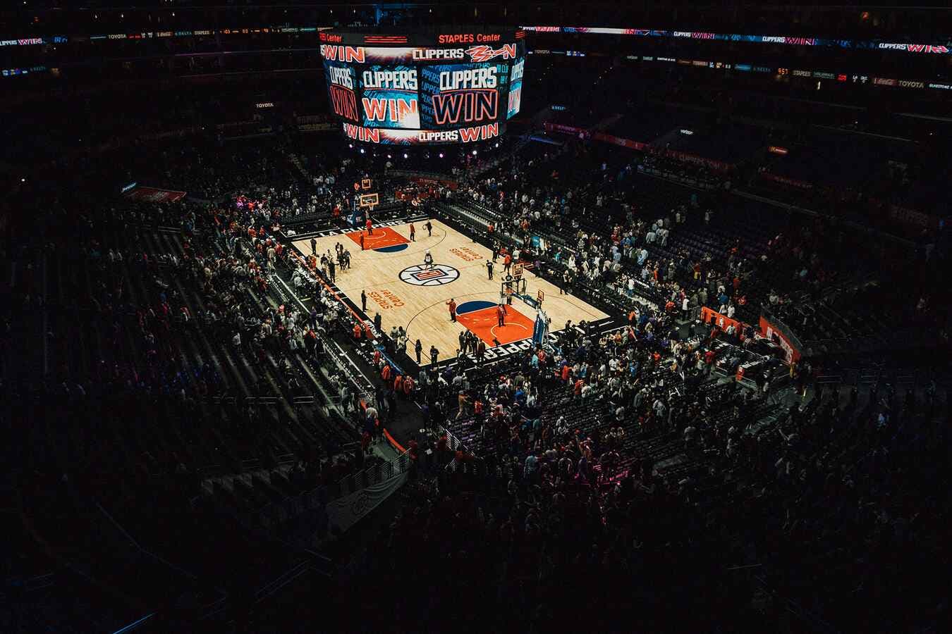 Basketball arena with jumbotron displaying game results